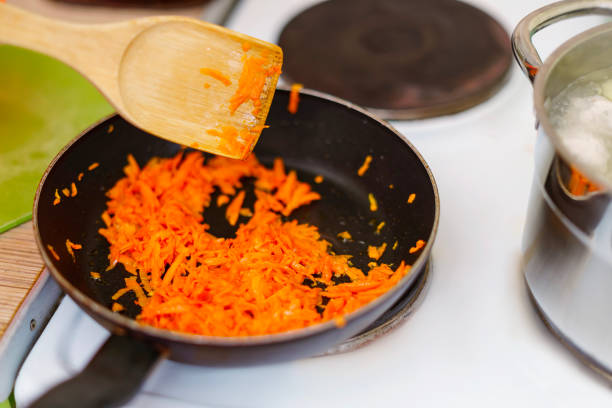Grated carrots are sauteed in a pan