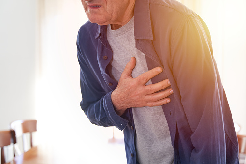 Heart attack concept. Senior man pressing hand on chest with pain