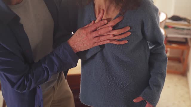 First aid in heart attack. Close up of husband helping wife with chest pain