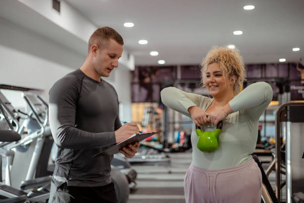 istock Plus Size Woman With Her Trainer Working Out With Kettlebell 1967962515