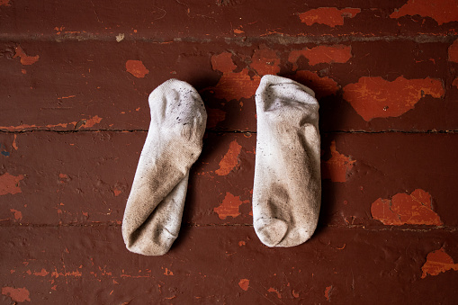 Dirty white short socks, dirty things lie on a wooden old floor