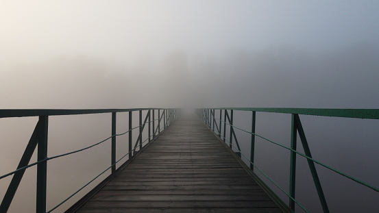 Bridge in the fog. Early morning in nature. Thick fog. Scenery. Mystical morning