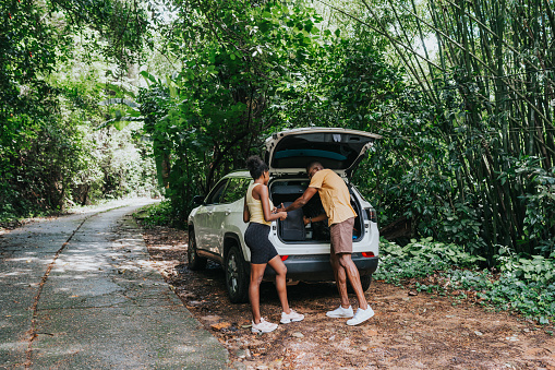 A romantic young couple in love are hugging near the car. Camping, weekend. Vacation, travel, tourism concept.