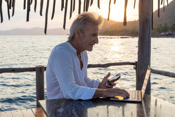istock Mature man works on laptop on pier 1967985266