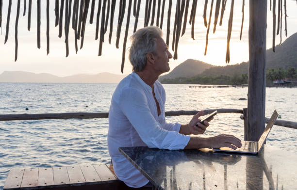 istock Mature man works on laptop on pier 1967988917