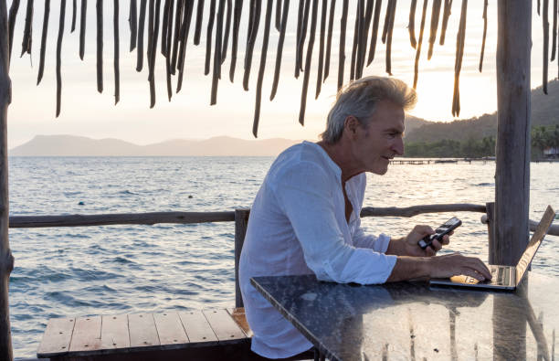 istock Mature man works on laptop on pier 1967990505