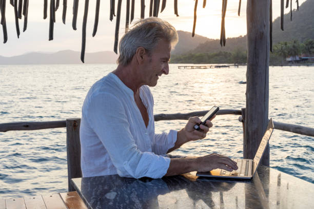 istock Mature man works on laptop on pier 1967990507