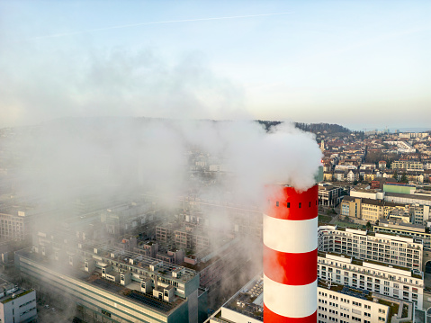 Chimney of the waste incineration plant on Josefstrasse Zürich with smoke and the city in the background
