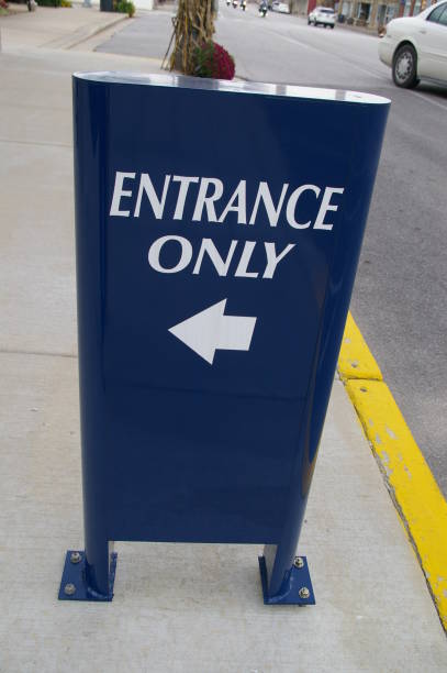 Blue and white entrance only sign on sidewalk