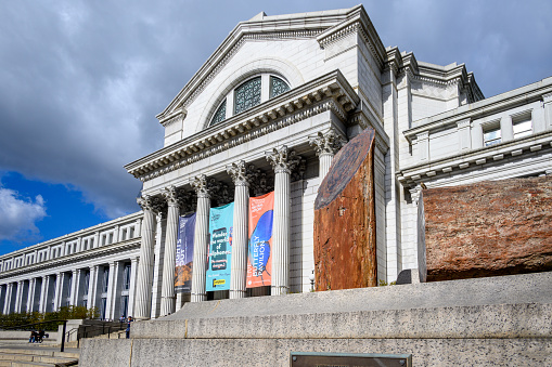Washington, DC -January 26, 2024: The exterior of the Smithsonian Institution Museum of Natural History. Petrified wood is displayed on a platform on front of the museum.