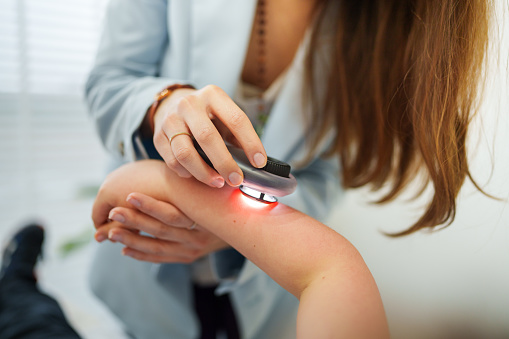 Dermatologist is using dermatoscope for skin examination