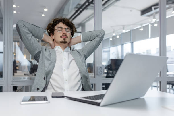 istock Young businessman in office relaxes from work, displaying stress relief and satisfaction 1968095580