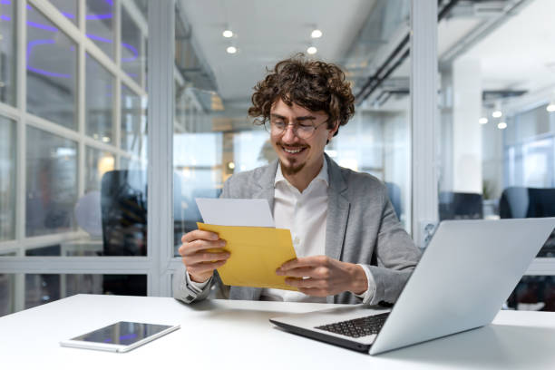 Successful businessman inside office at work, man received notification mail with good news, hispanic man in business suit using laptop at work smiling and reading notification. hombre de negocios exitoso dentro de la oficina en el trabajo, el hombre recibió el correo de notificación con buenas noticias, hombre hispano en traje de negocios usando computadora portátil en el trabajo sonriendo y leyendo la notificación