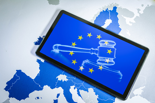 EU Flag with gavel and sound block on smartphone screen over a Eu map. Suitable for concepts as Artificial Intelligence or AI Act, European union Legal sistem and Directives.