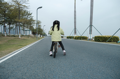 Little girl riding bicycle on the road