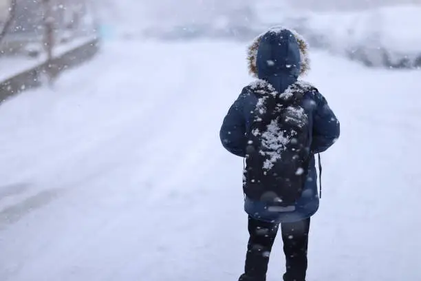 Happy kid boy with having fun with snow on way to school Happy kid boy with having fun with snow on way to school