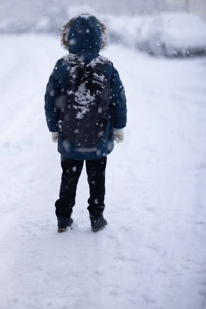 istock Happy kid boy with having fun with snow on way to school 1968108327