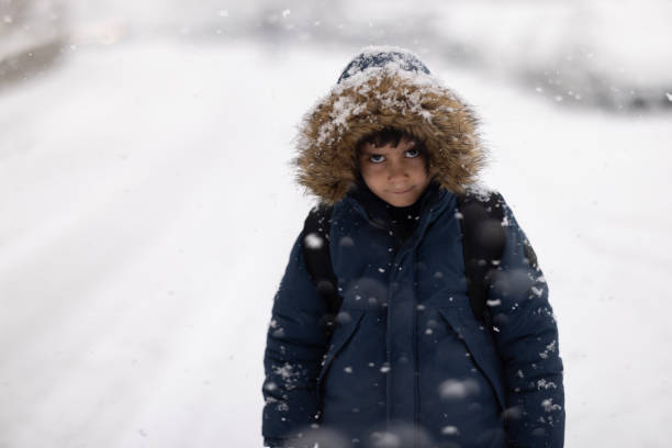 istock Happy kid boy with having fun with snow on way to school 1968108335