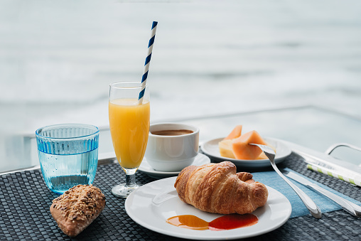 a tray with a breakfast on an outdoor terrace and the sea in the background. breakfast and vacation concept.