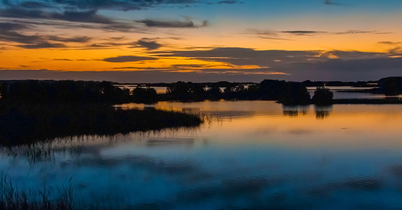 Beautiful sunset over the swamp in Louisiana, the reflection of clouds in the water, USA