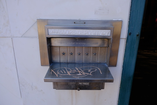 Envelope deposit thing on the wall outside of an abandoned bank in downtown Lafayette Louisiana.