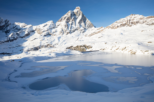 Panoramic view of the Matterhorn, on the Italian side, on a winter afternoon. In the foreground is the completely frozen Goillet Lake. In the background the majestic Matterhorn.