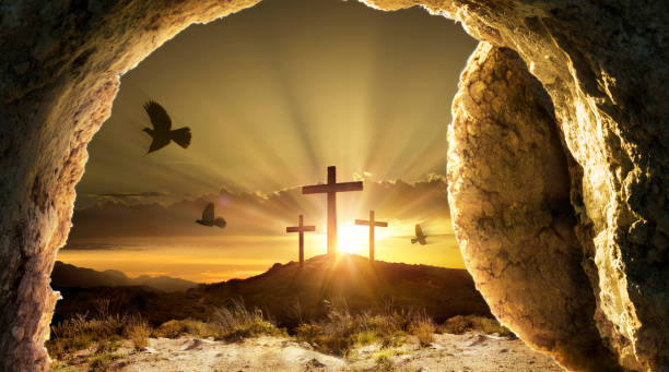 Resurrection - Empty Tomb With Rolled Stone And Doves Flying Out Of Cave - Crosses On Hill At Sunrise stock photo