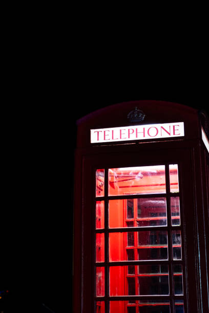 istock Vintage British Red Telephone Box Illuminated At Night 1968186526