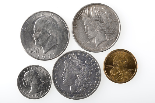Different types of U.S. Silver Dollars on white background.