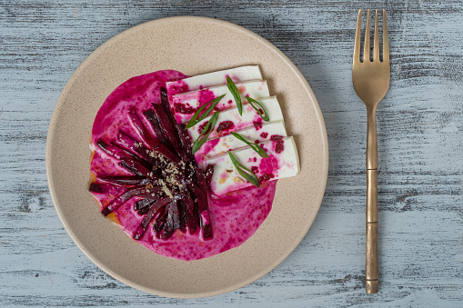 Boiled beet salad with soft feta cheese and sauce, close up, top view