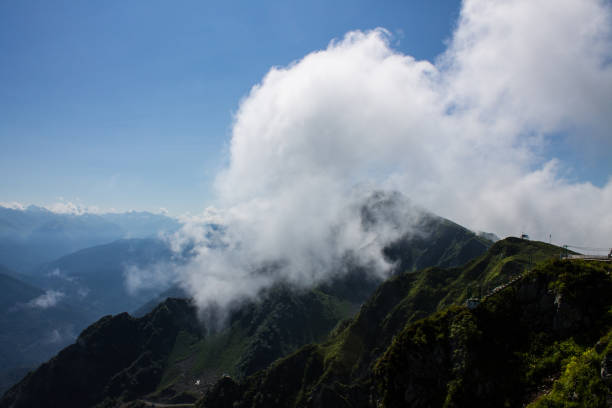 istock Panoramic view with mountain peaks and large white clouds 1968223654