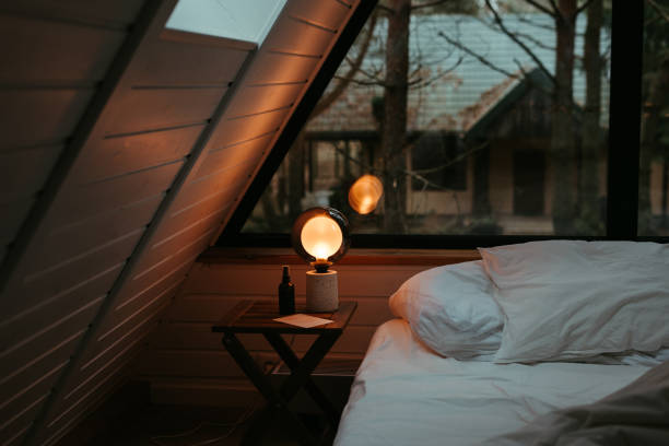 the light is shining on a bed that has a lamp on