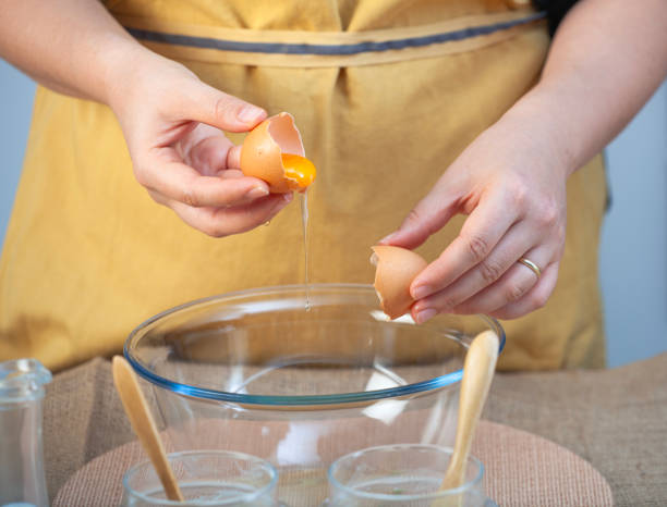 istock Close up of a woman cracking an egg. 1968251901