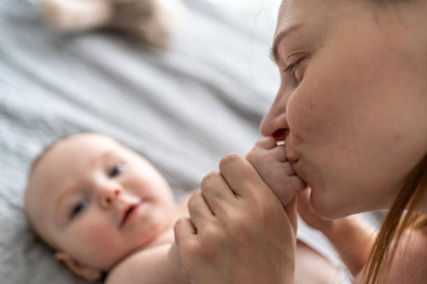 istock Mother kissing baby boy while playing at home 1968256582