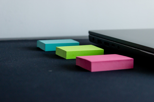 Vibrant sticky notes alongside a sleek, closed laptop.