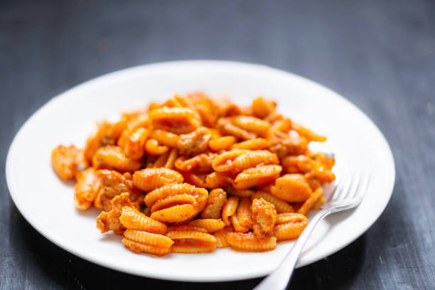 close up of a plate of gnocchetti pasta in sausage tomato sauce