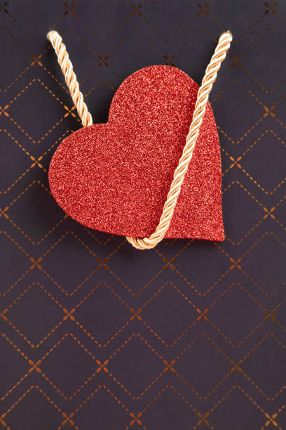 Heart made of red yarn on a wooden board. Space for text.