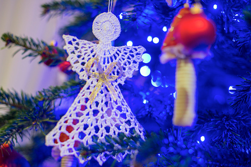 Selective Focus On Handcrafted Crochet White Angel Hanging On Christmas Tree. Christmas Tree Decoration.