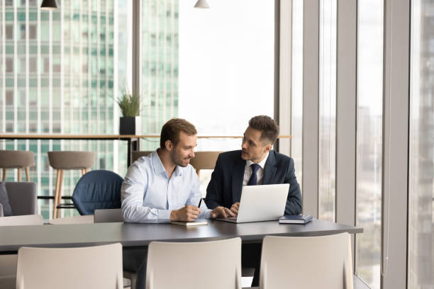 istock Two positive business partners men talking at workplace 1968394019