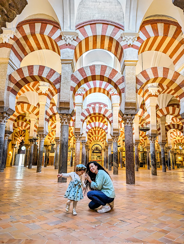 Mother and young daughter enjoying the interior of the Mosque Cathedral of Cordoba in Spain