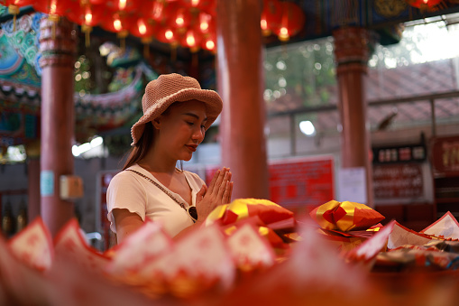 Woman pray to respect god by Incense at the temple, woman lighting incense sticks to pay homage to the Chinese New Year