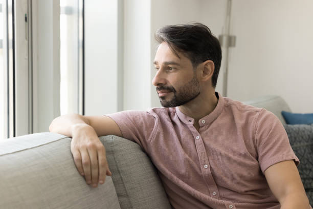 istock Positive thoughtful relaxed middle aged man sitting on comfortable couch 1968453619
