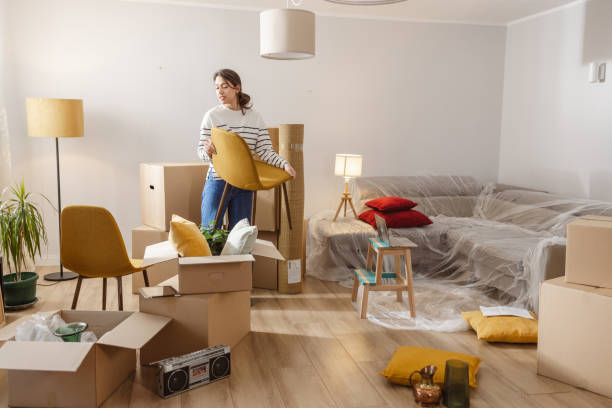 istock Smiling young woman surrounded by boxes while moving, unpacking personal belongings 1968484639