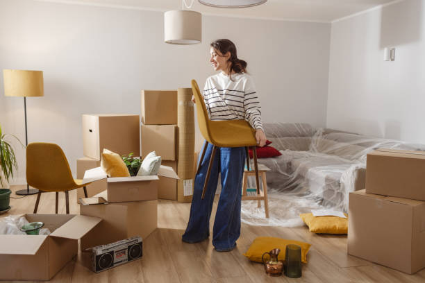 istock Smiling young woman surrounded by boxes while moving, unpacking personal belongings 1968486715