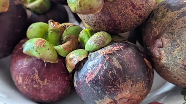 istock closeup of mangosteen fruit on a white plate 1968520245