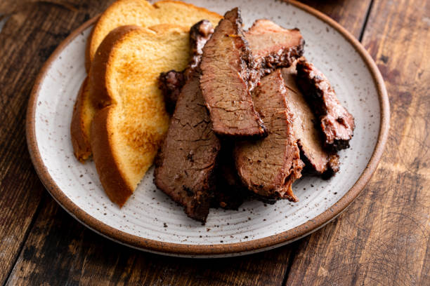 Sliced smoked brisket on a plate with toast