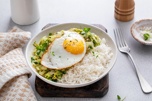 Rice bowl with sauteed cabbage and fried egg, healthy lunch or breakfast
