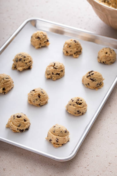 istock Chocolate chip cookie dough scoopes on a cookie sheet ready to be baked 1968539110