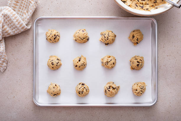 istock Chocolate chip cookie dough scoopes on a cookie sheet ready to be baked 1968539116