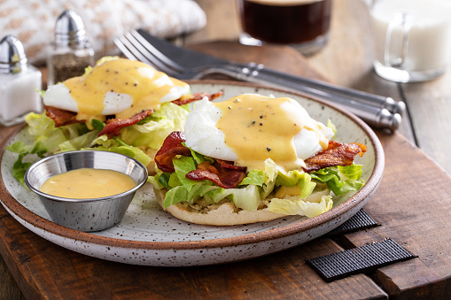 Egg benedict sandwiches with bacon and fresh lettuce and hollandaise sauce for breakfast